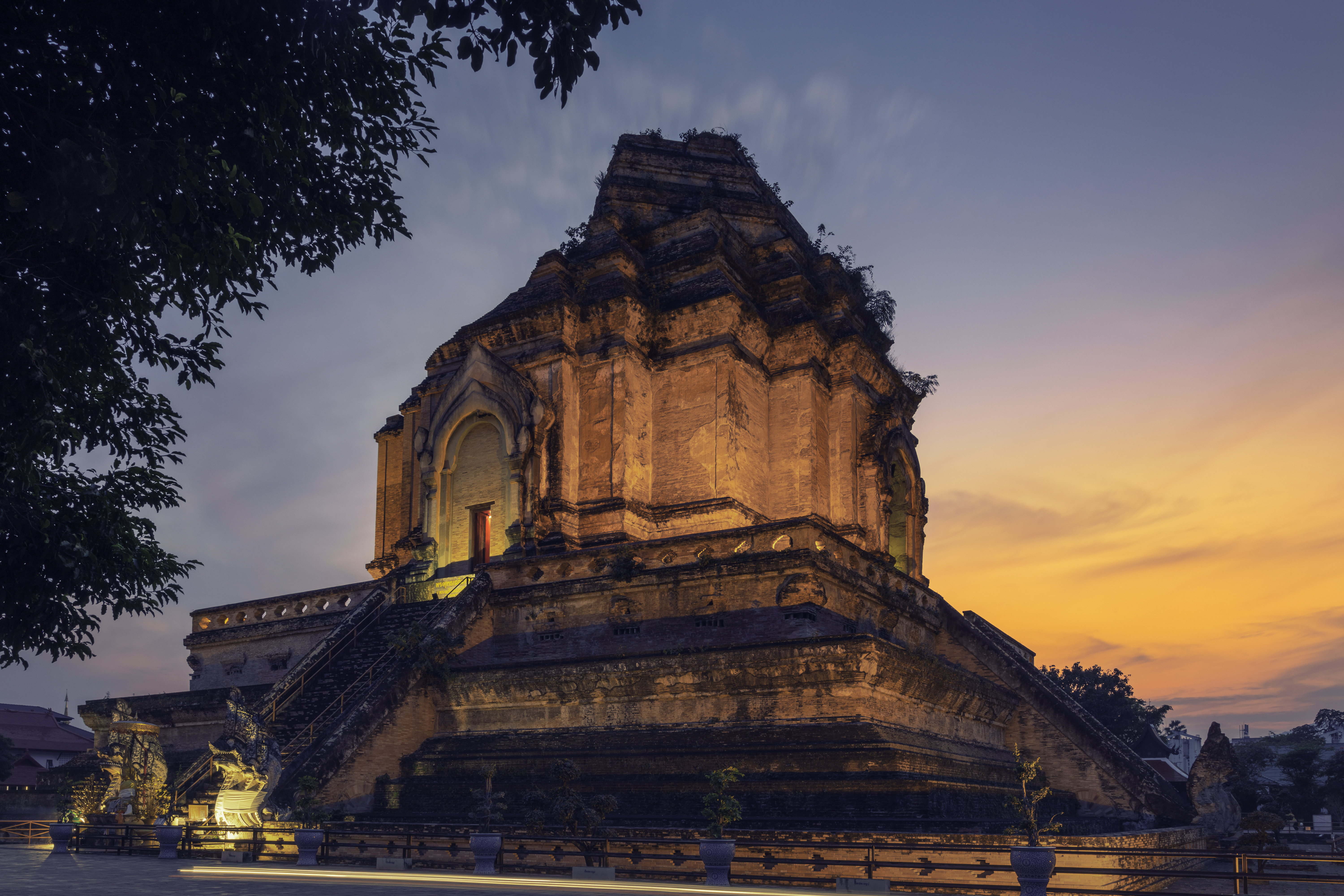 a large stone building with stairs and trees