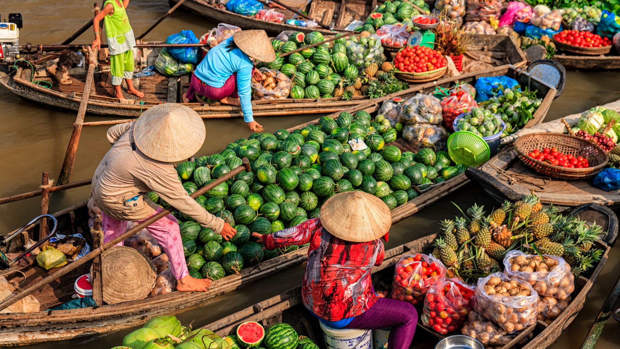 a group of people in boats with fruits and vegetables