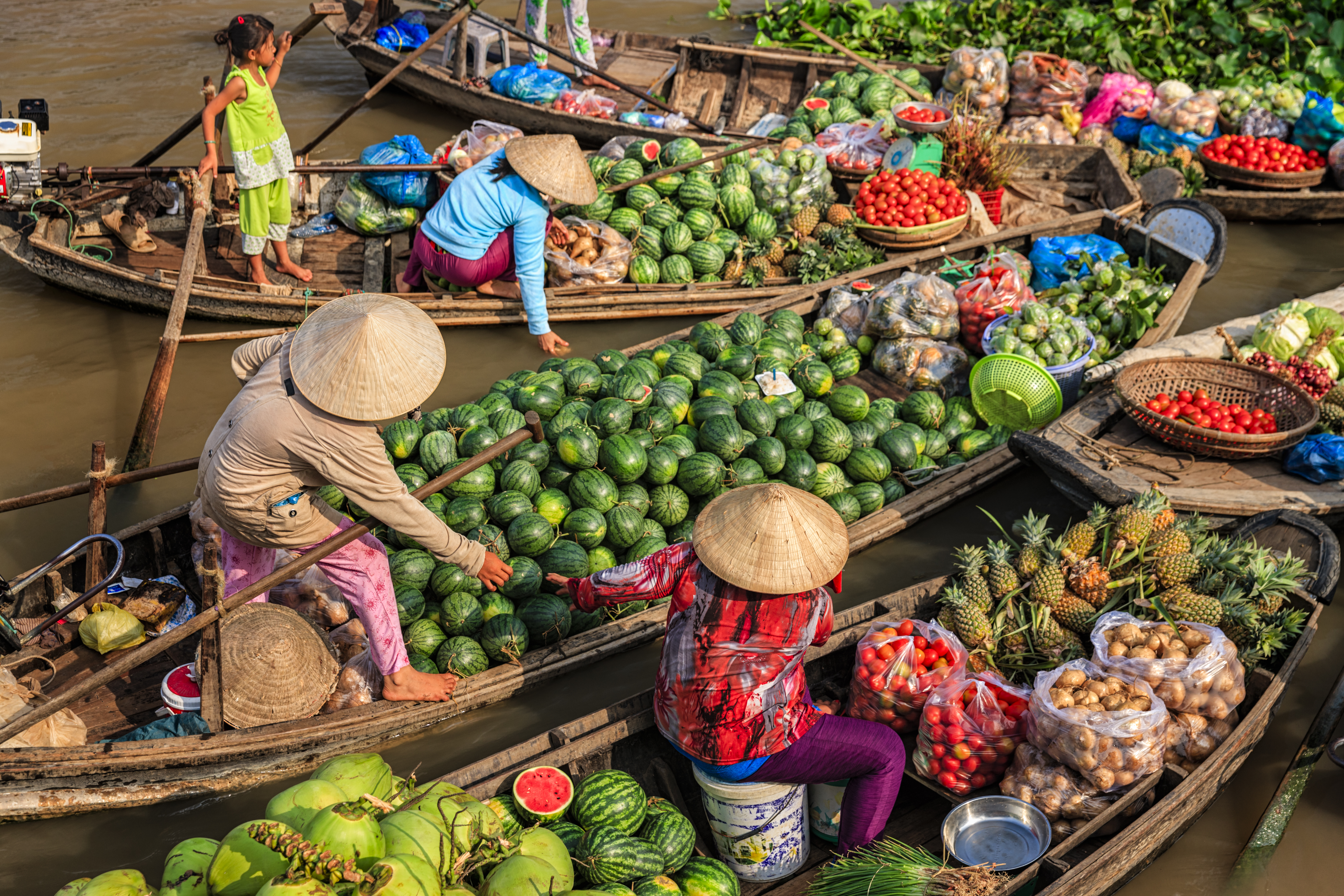 a group of people in boats with fruits and vegetables