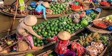 a group of people in boats with fruits and vegetables