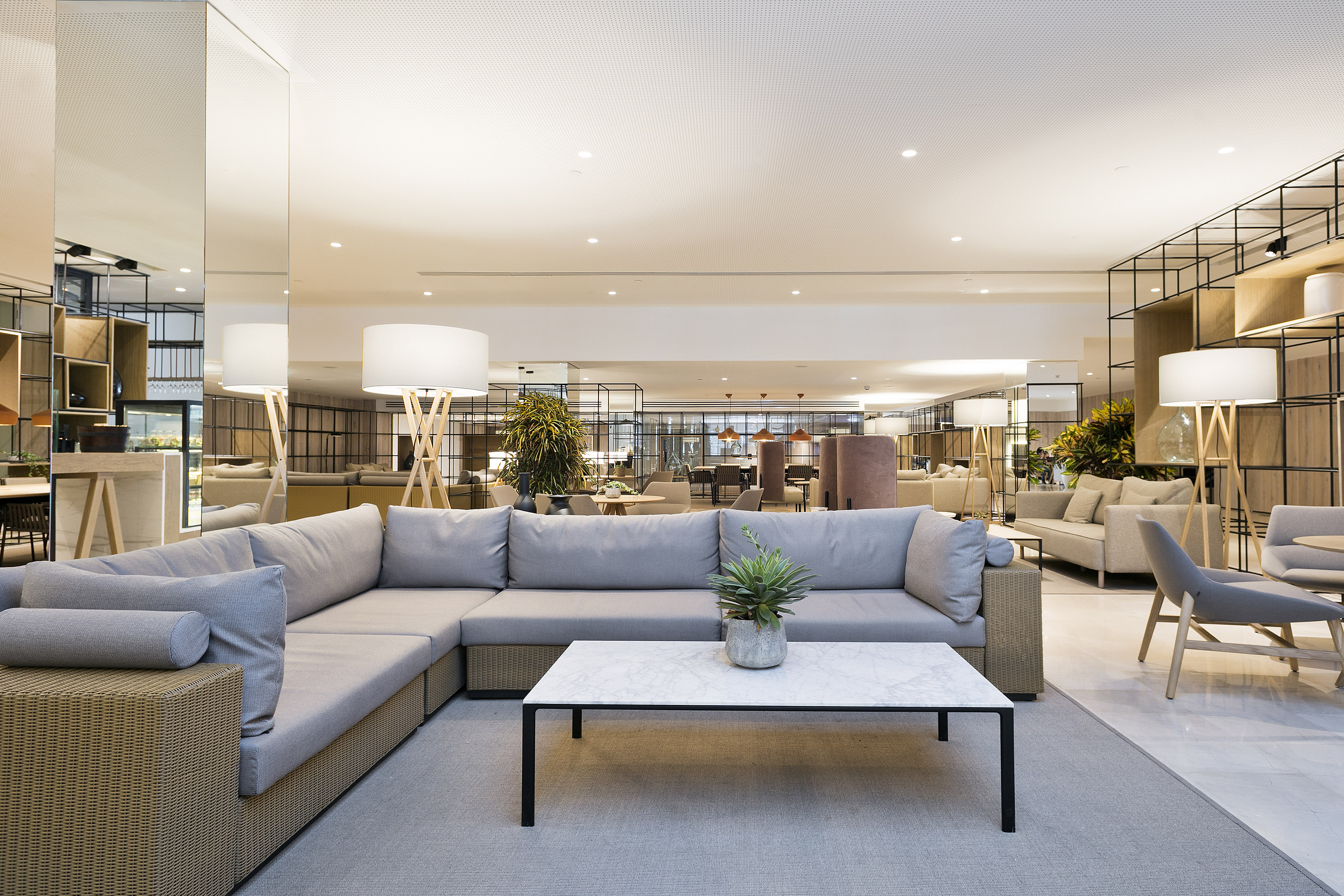 Contemporary hotel lounge with gray sectional sofa and marble coffee table.