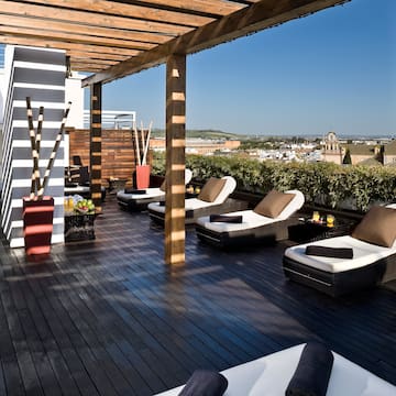 a deck with lounge chairs and a view of the city