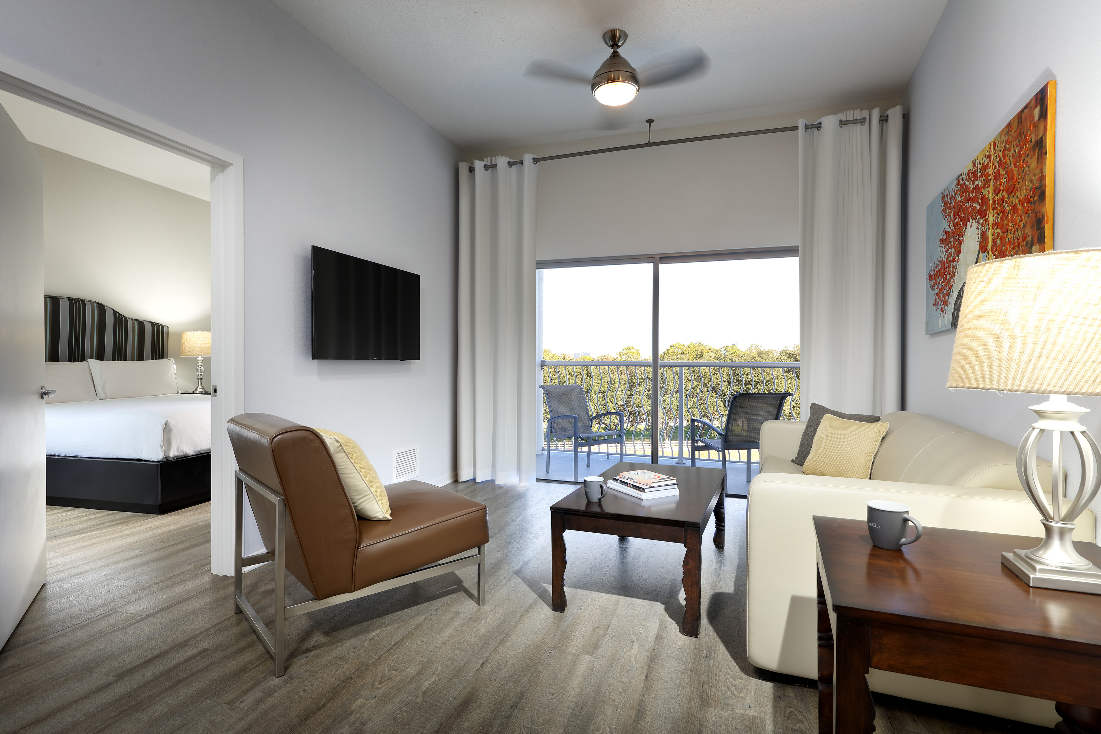 Apartment living room with balcony access, modern furniture, and TV. - One-Bedroom Suite King-Size Bed - Meliá Orlando Celebration, Orlando