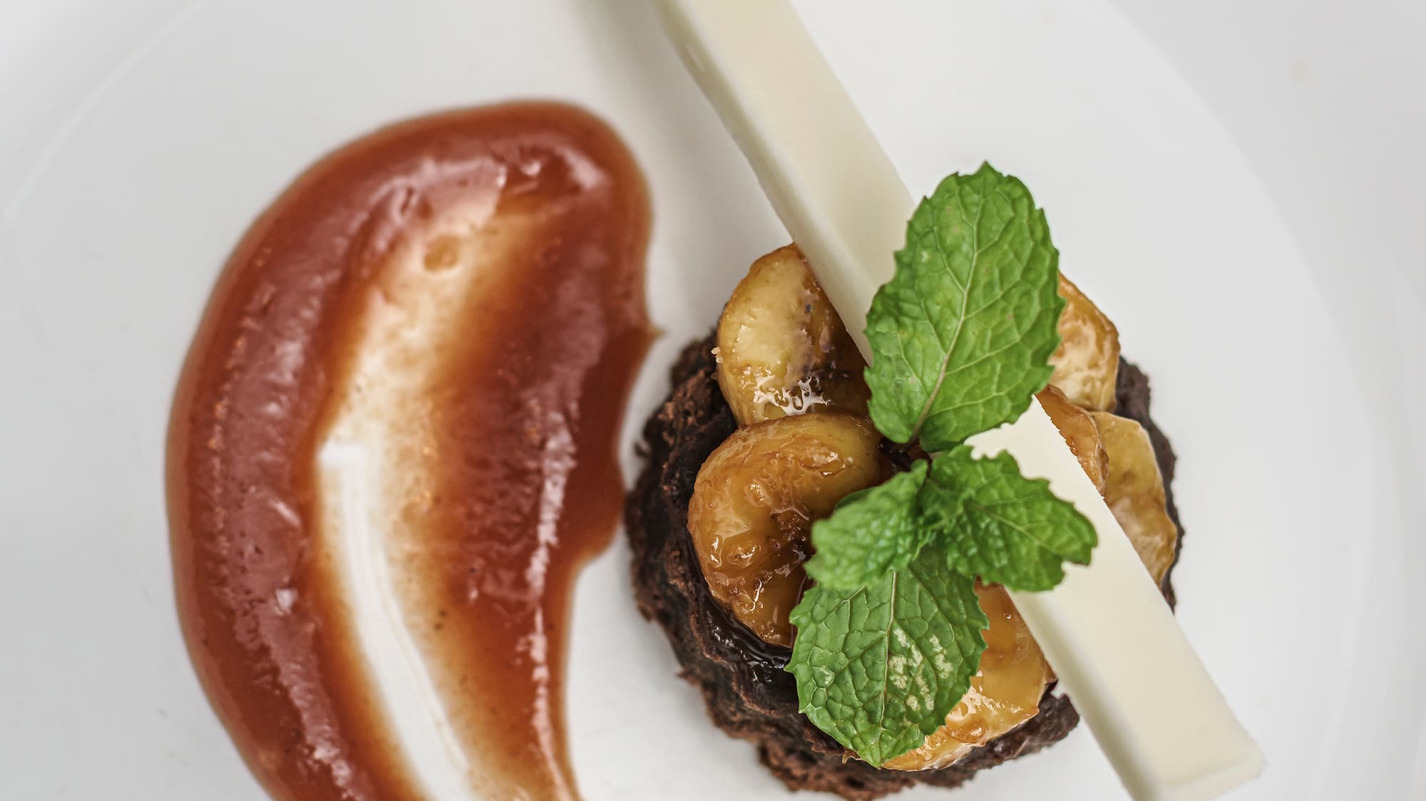 a plate of food with a slice of banana and sauce