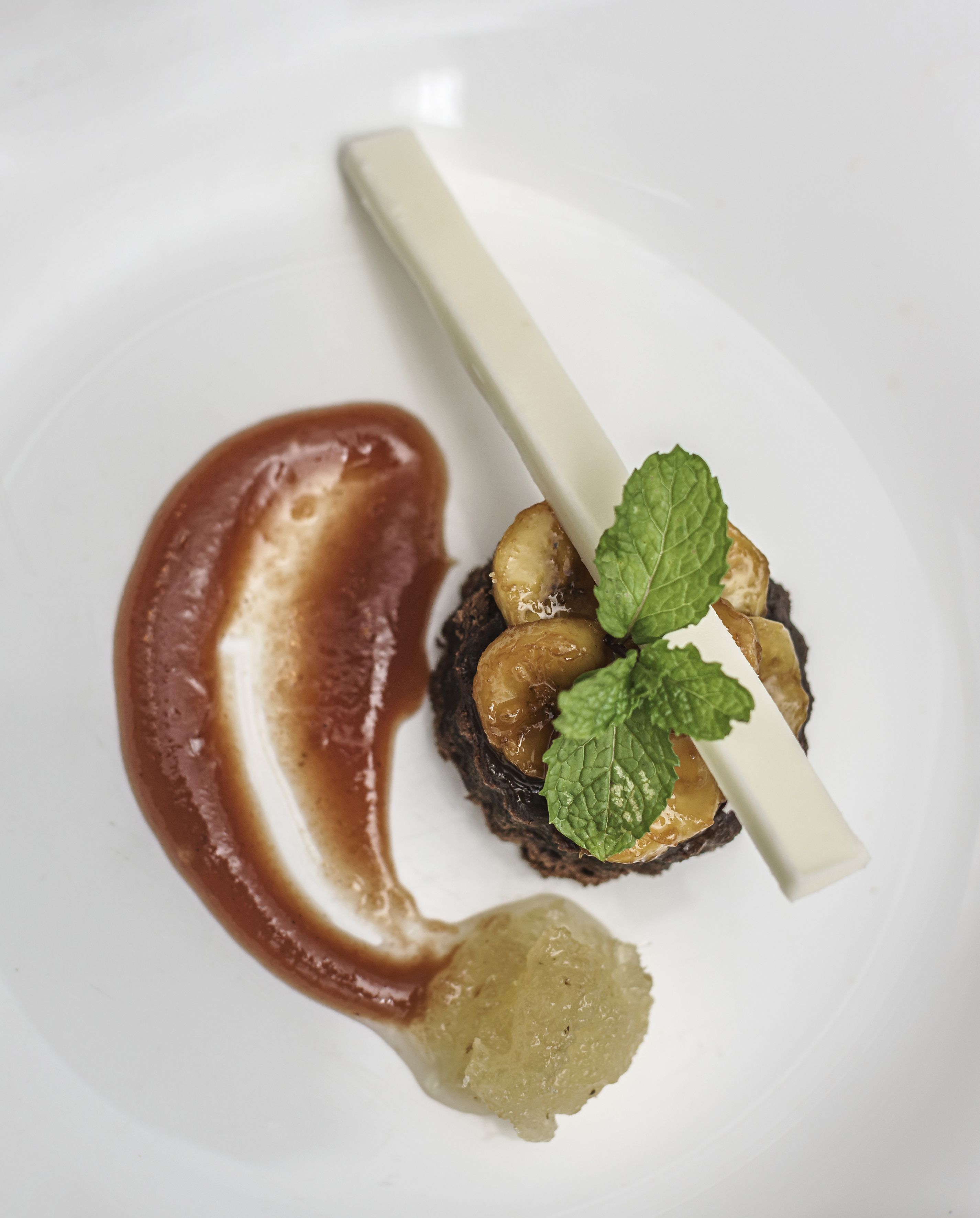 a plate of food with a slice of banana and sauce