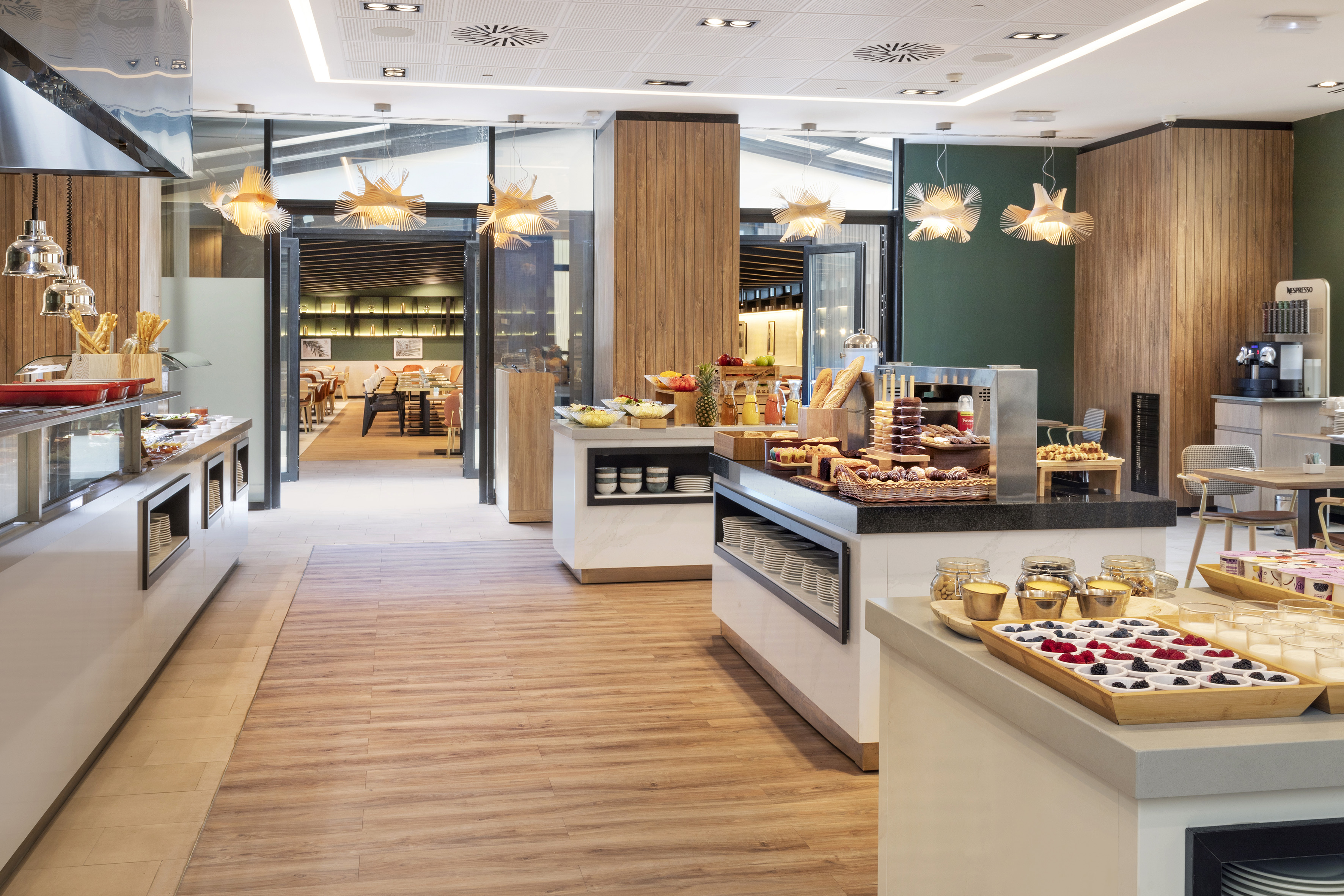 Modern hotel restaurant breakfast buffet with fresh food and pastries.