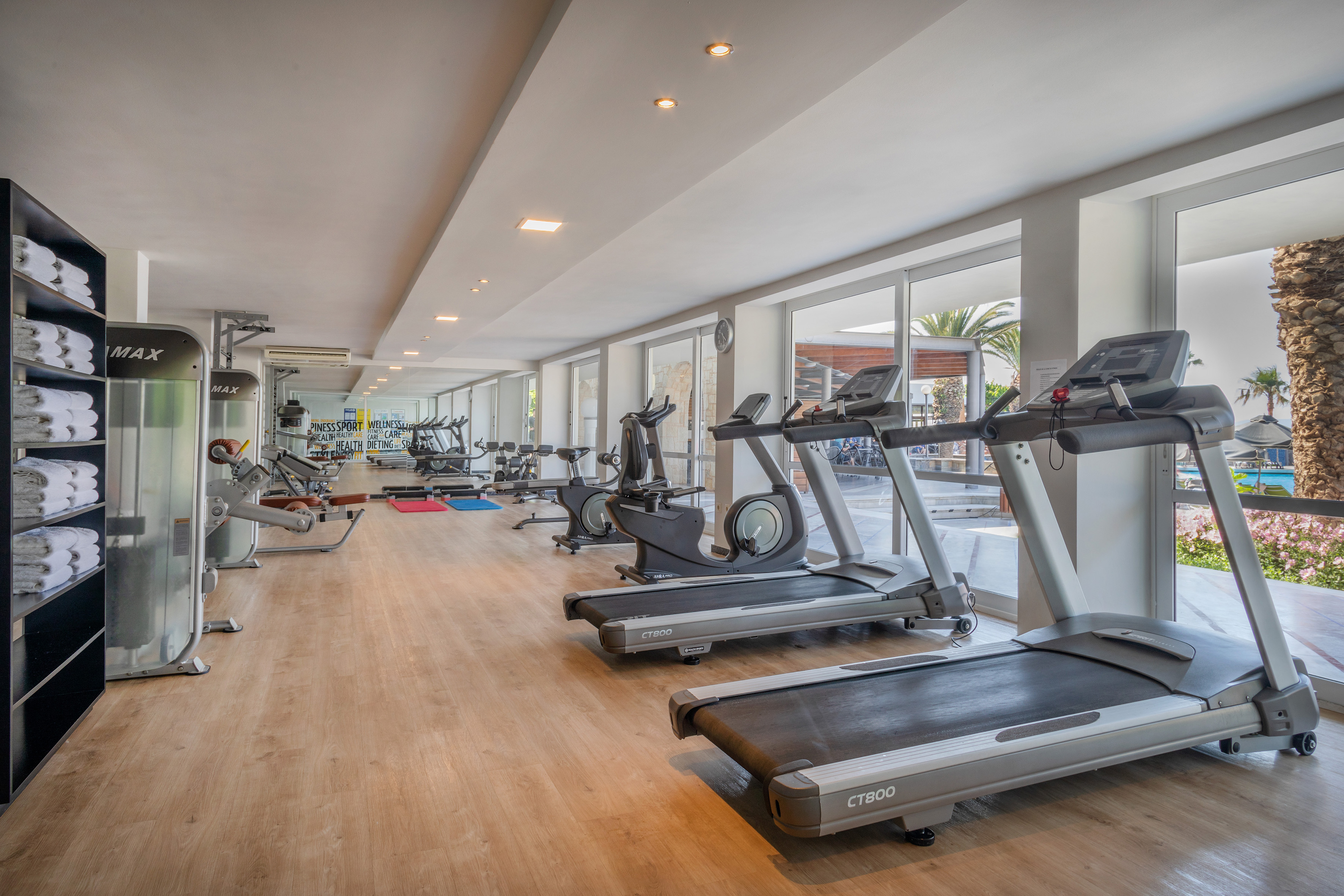 Resort gym with treadmills, bikes, strength equipment, large windows, and outdoor view.