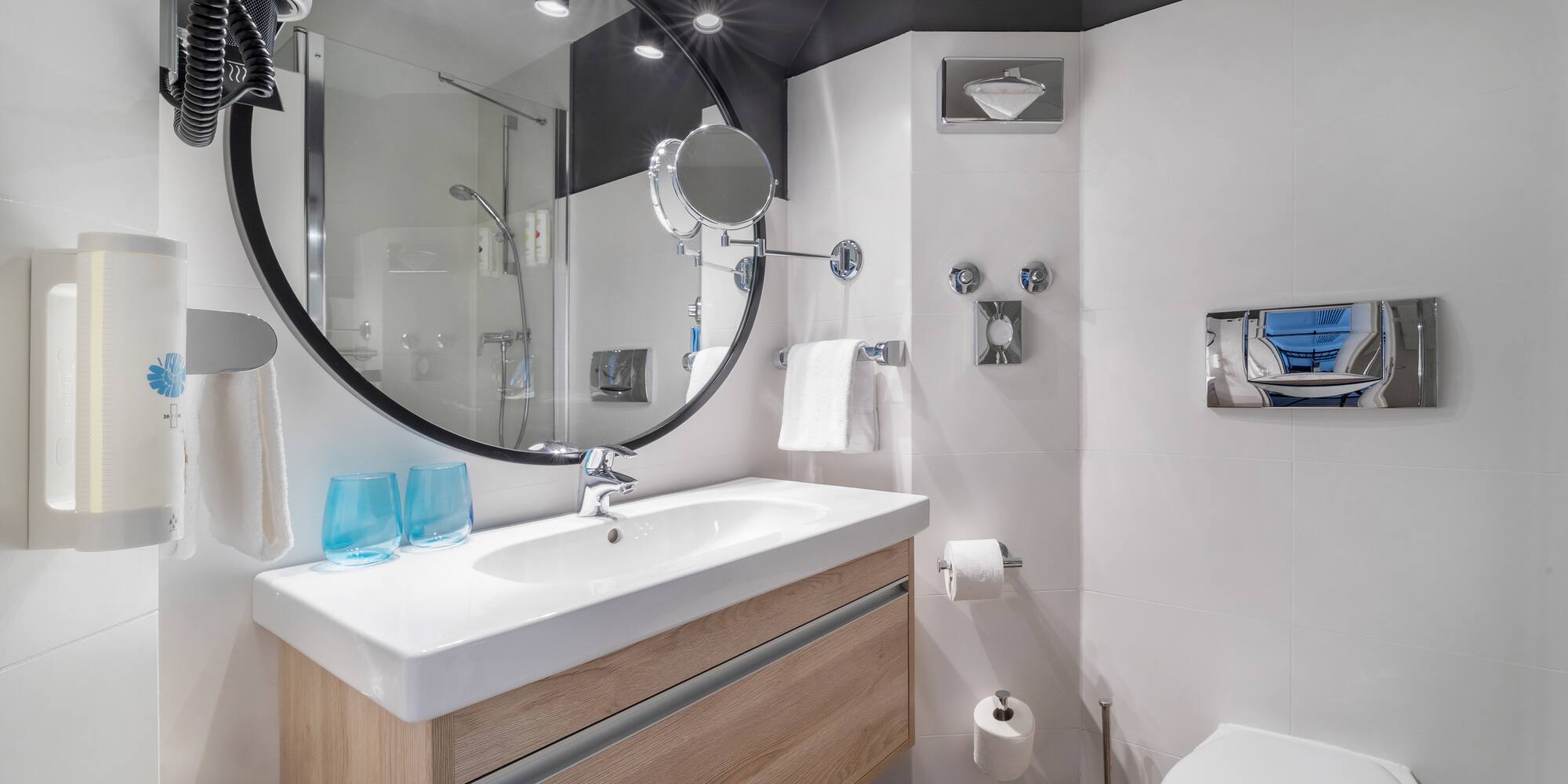a bathroom with a round mirror and a toilet