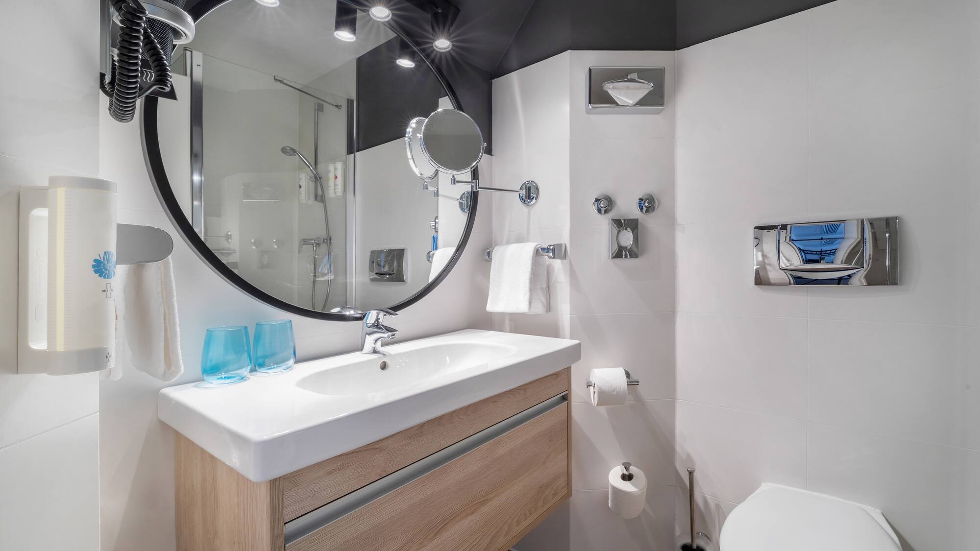 a bathroom with a round mirror and a toilet