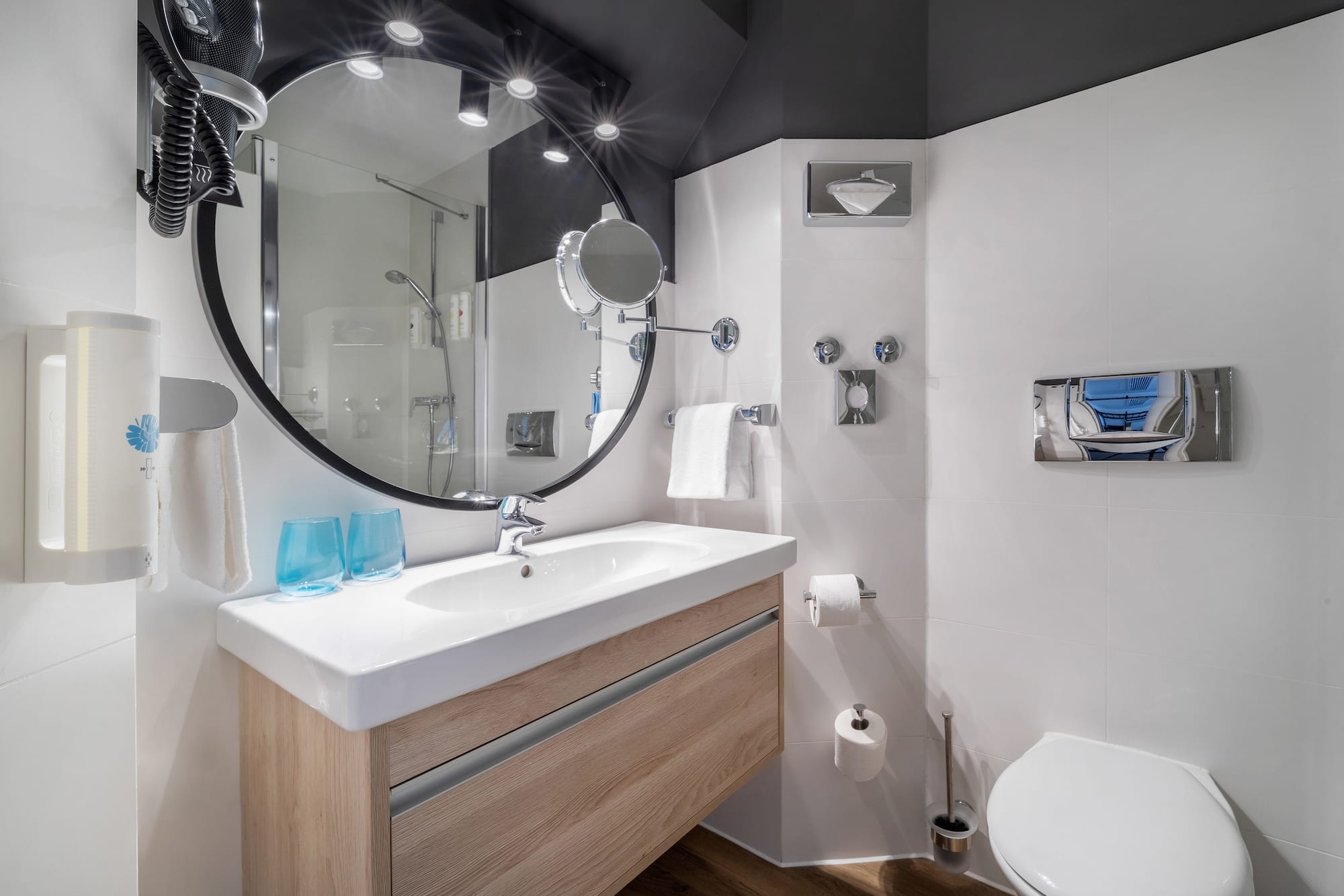 a bathroom with a round mirror and a toilet