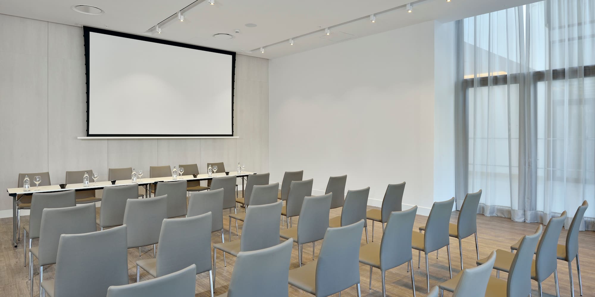 a room with chairs and a projector screen