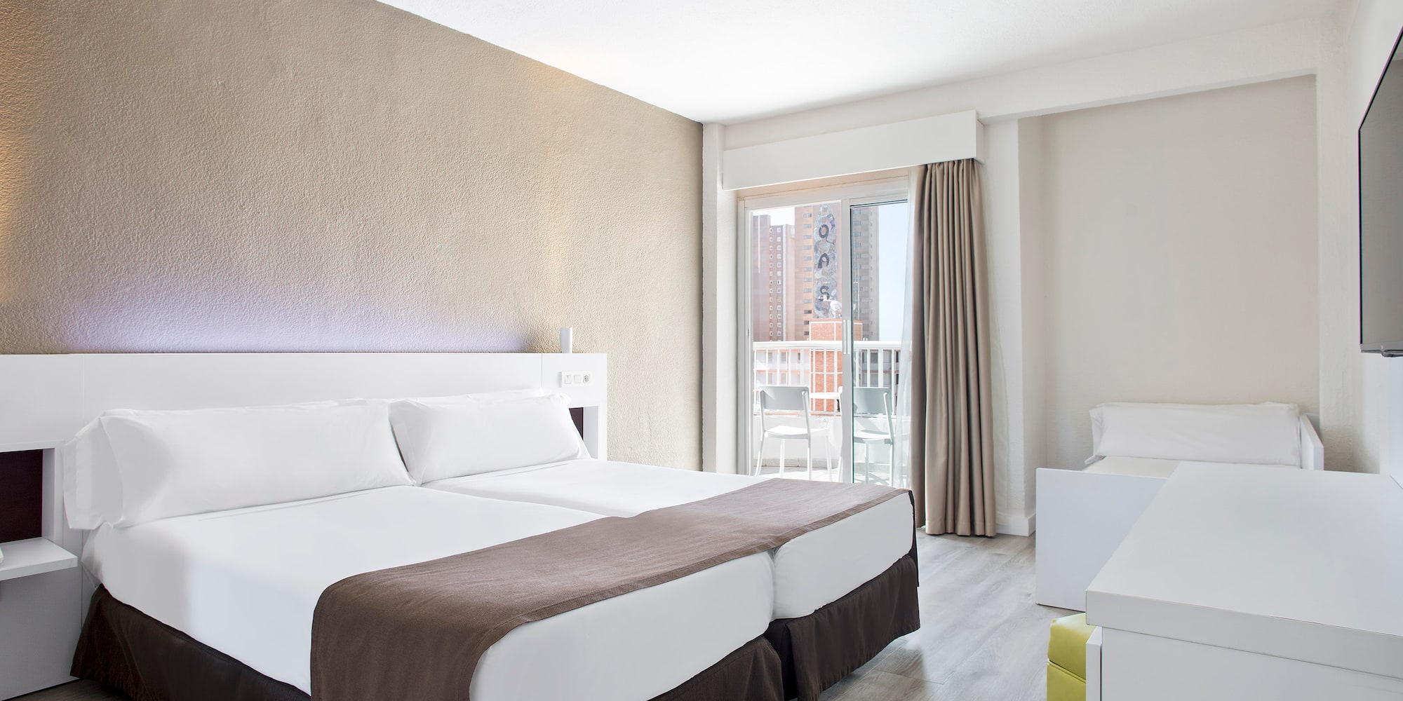 a room with two beds and a balcony