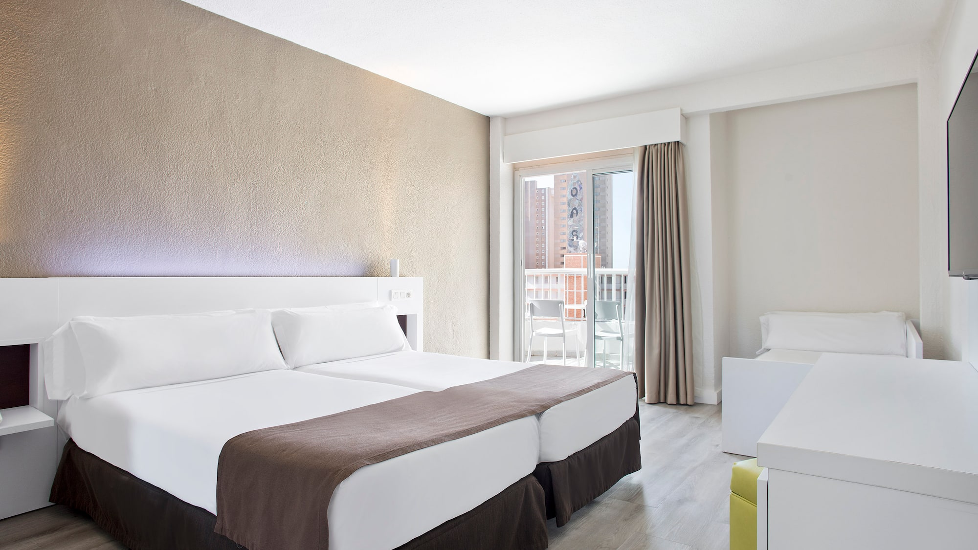 a room with two beds and a balcony