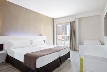 a room with two beds and a balcony