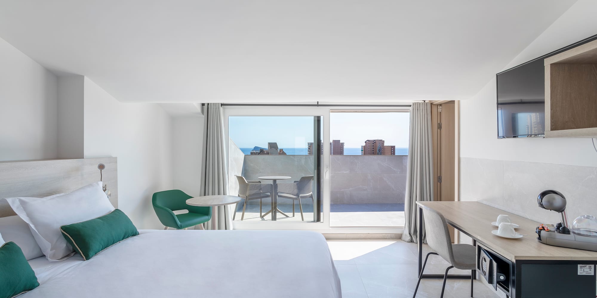 a bedroom with a bed and a desk and a television