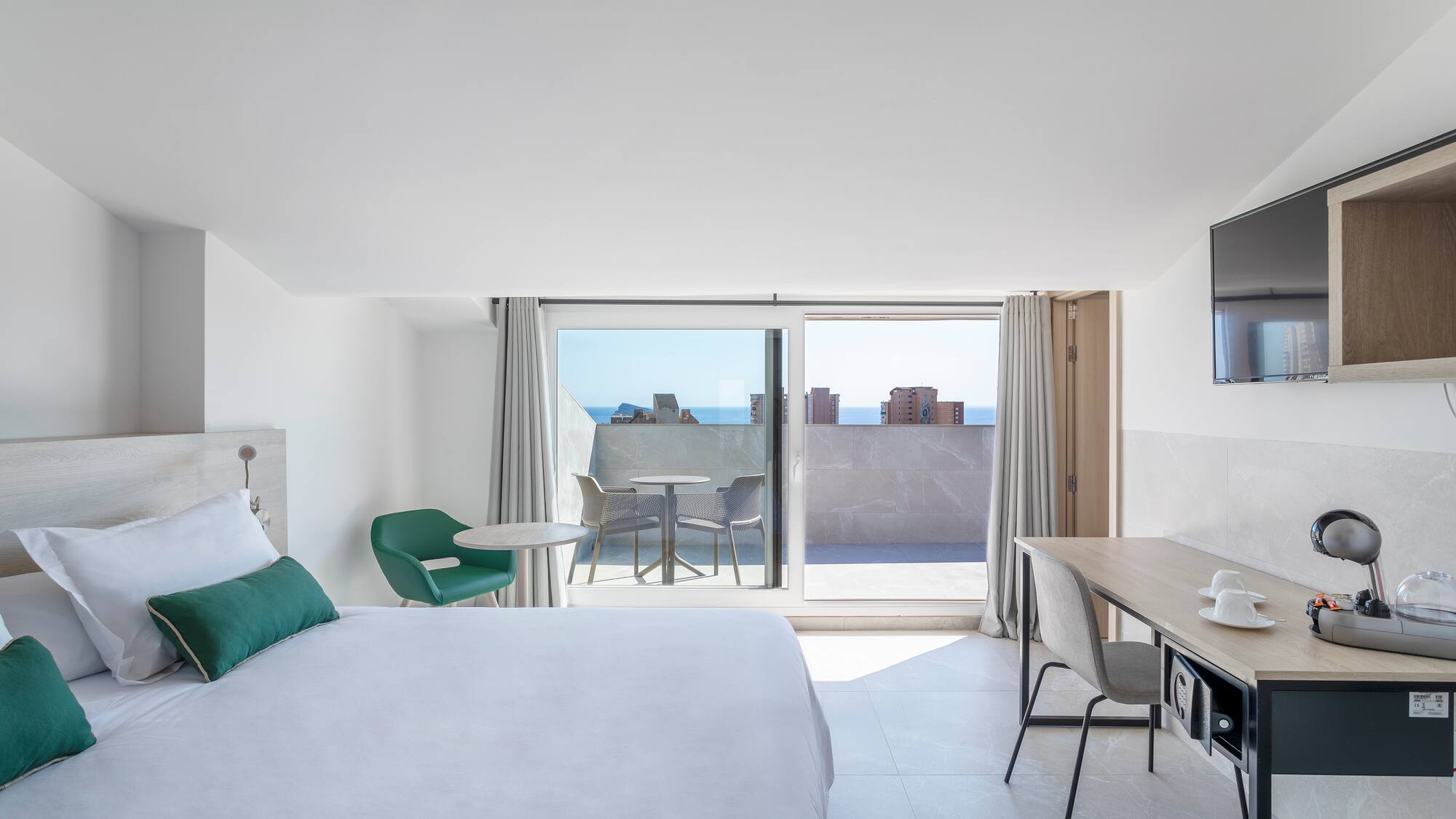 a bedroom with a bed and a desk and a television