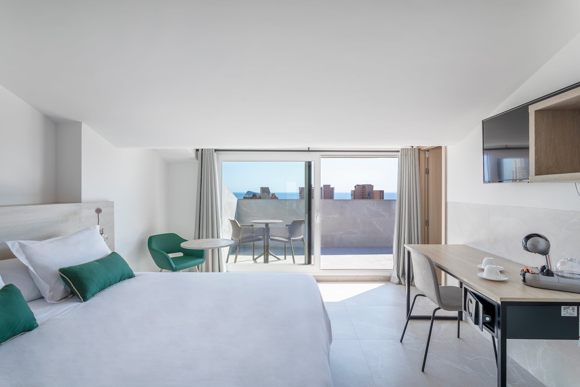 a bedroom with a bed and a desk and a television