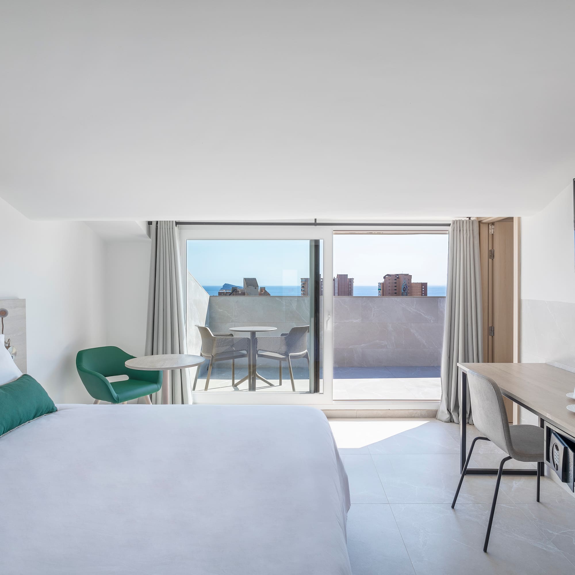 a bedroom with a bed and a desk and a television