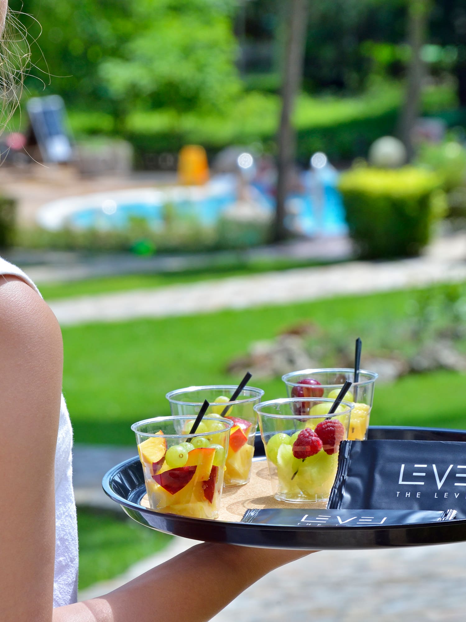 a woman holding a tray of fruit