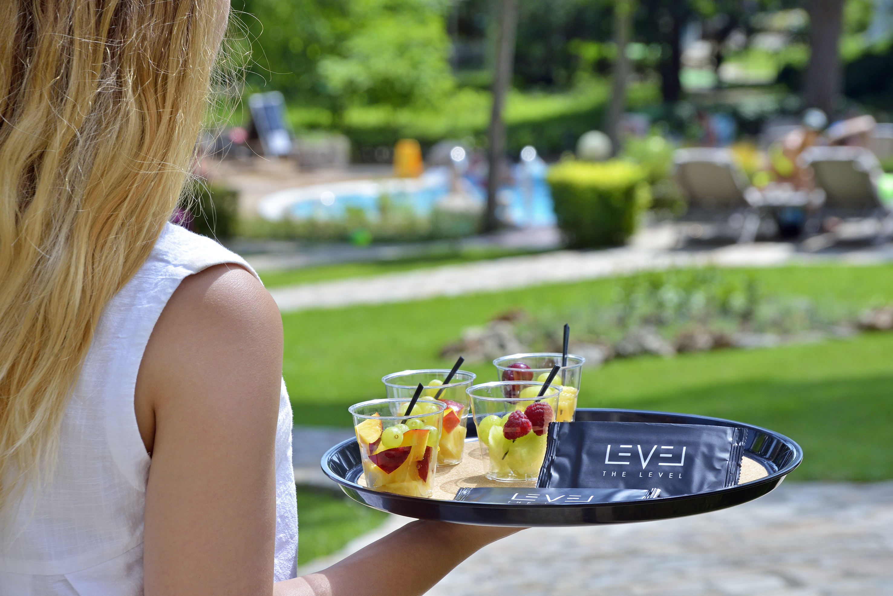 a woman holding a tray of fruit
