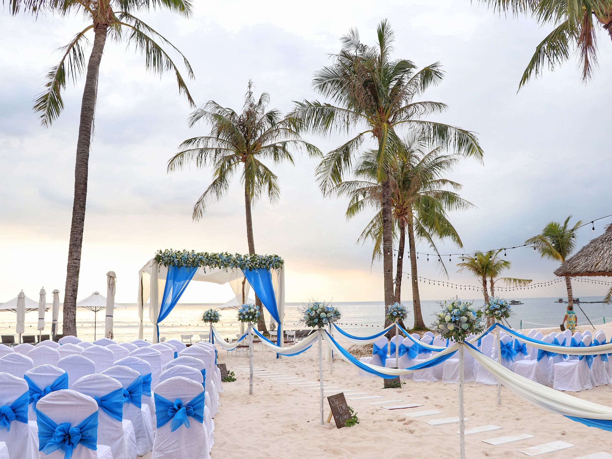 a beach wedding set up with palm trees and chairs