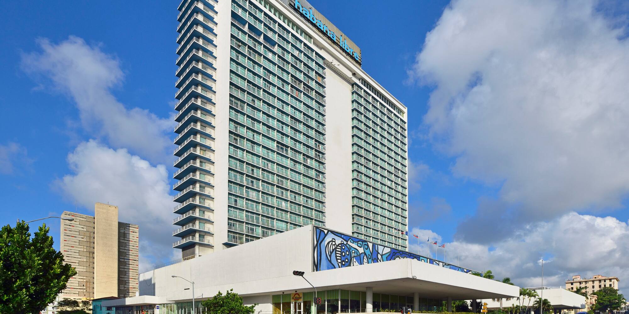 a large building with cars and a blue sky