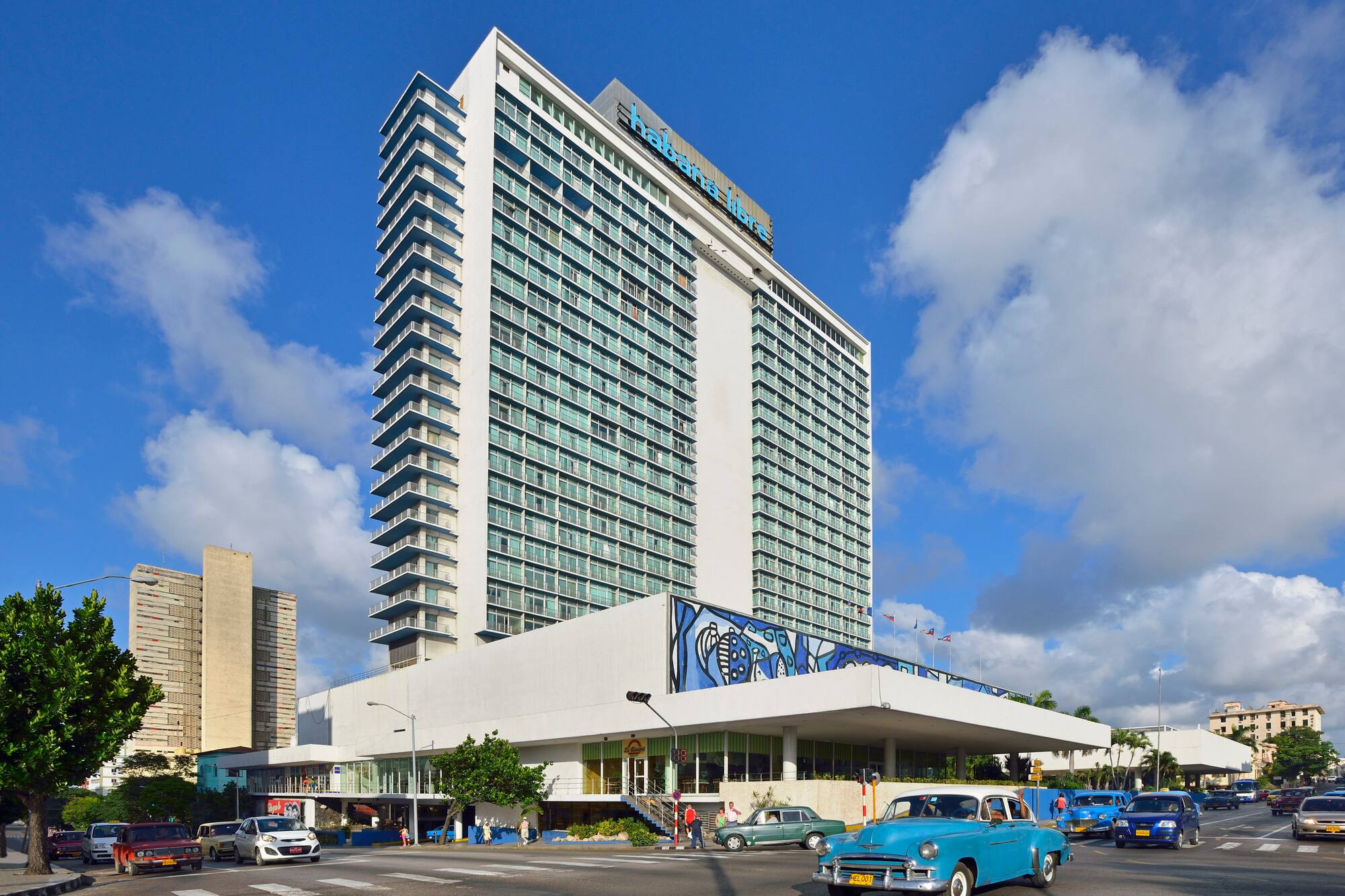 a large building with cars and a blue sky