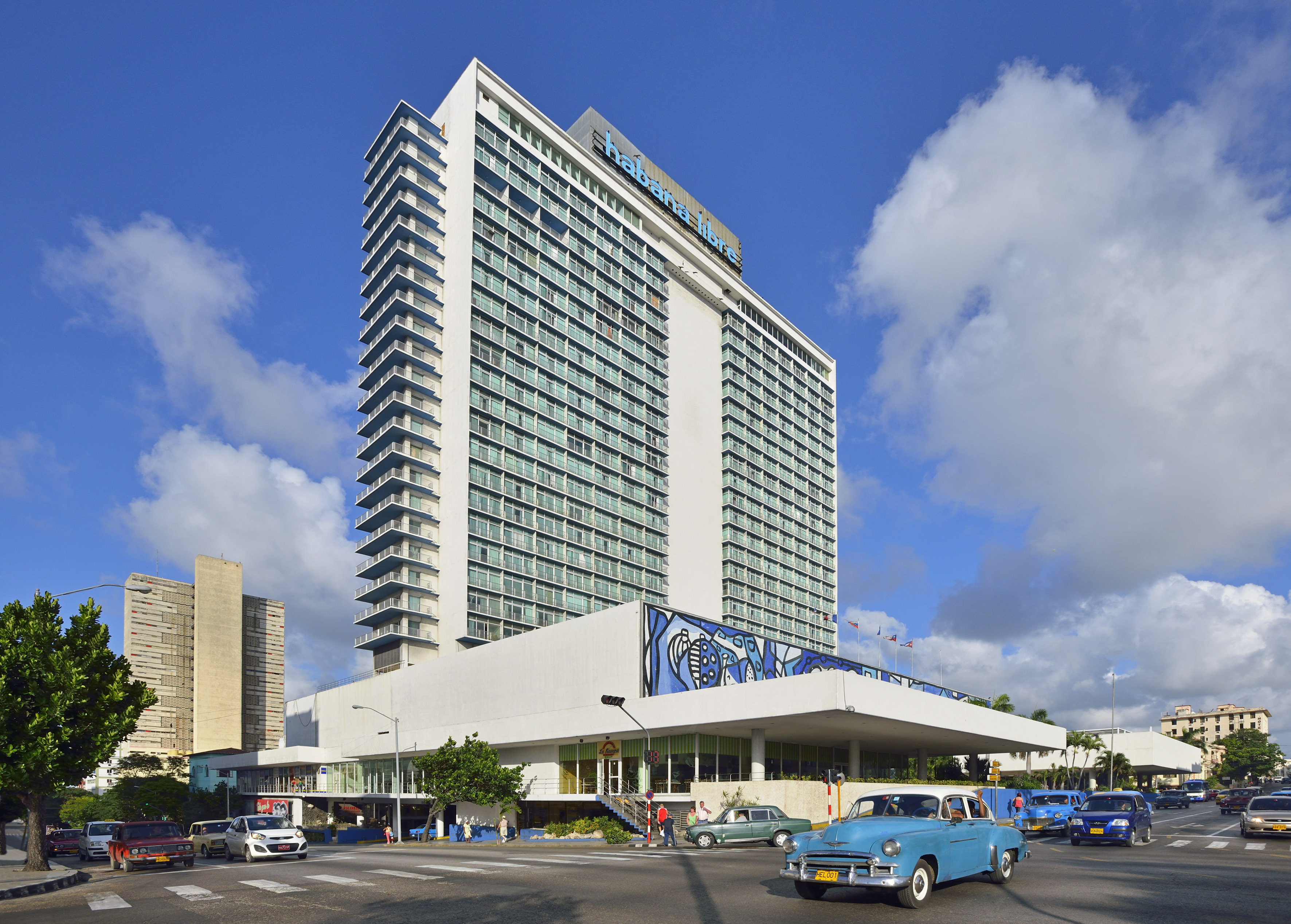 a large building with cars and a blue sky