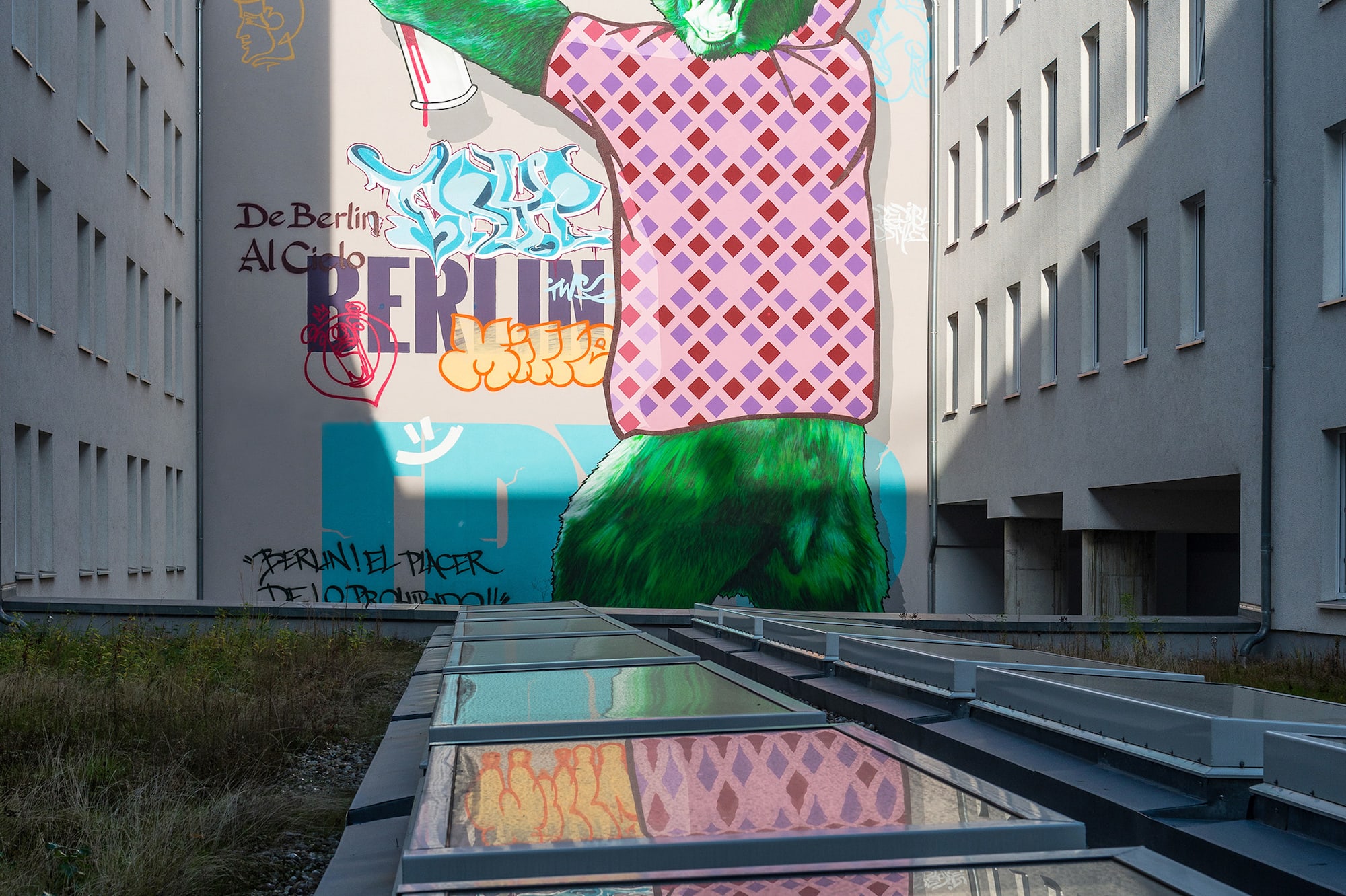 Berlin street art mural: green bear in patterned shirt, 'I ❤️ BLN', reflected.