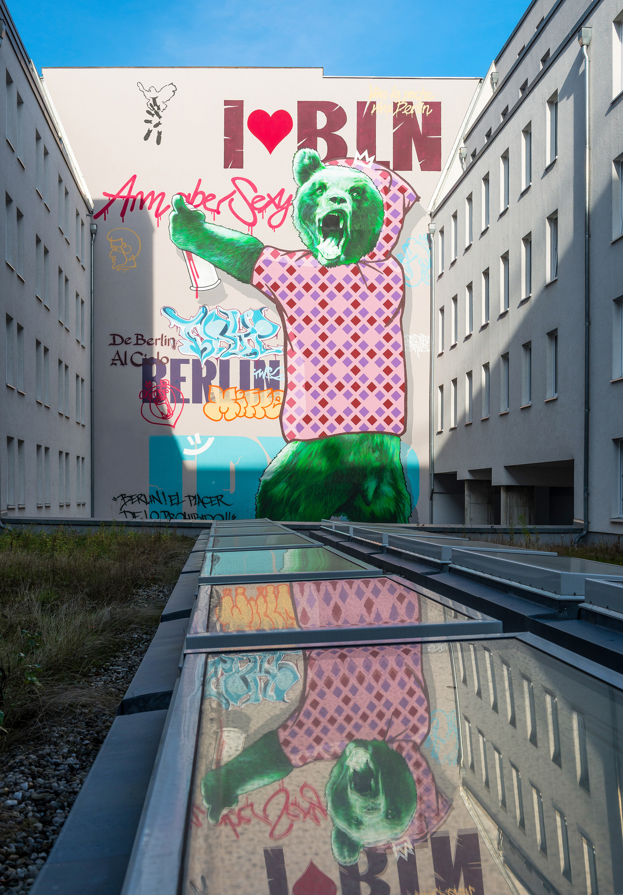 Berlin street art mural: green bear in patterned shirt, 'I ❤️ BLN', reflected.