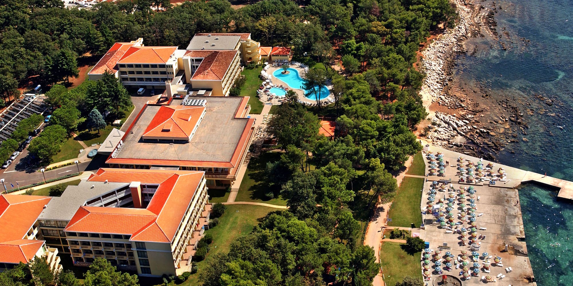 a resort with a pool and trees by the water