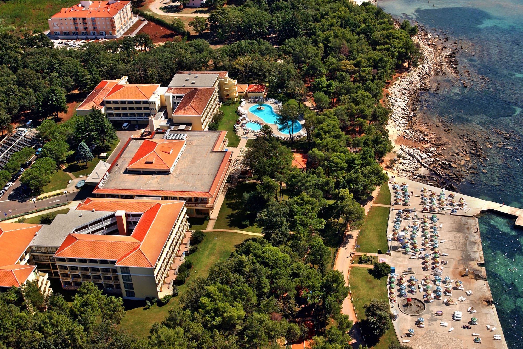 a resort with a pool and trees by the water