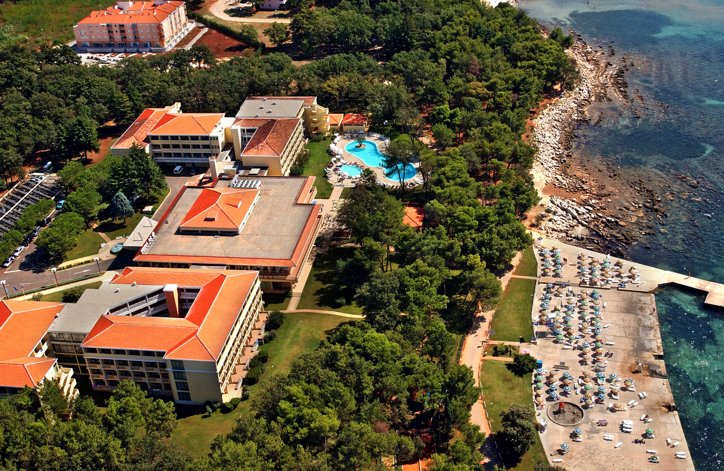 a resort with a pool and trees by the water