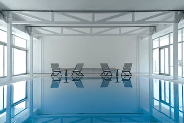 a pool with chairs and tables in it