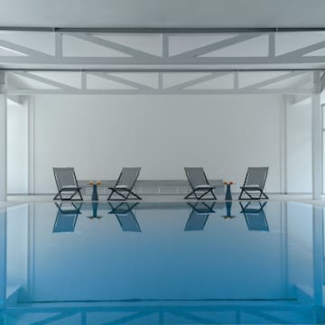 a pool with chairs and tables in it