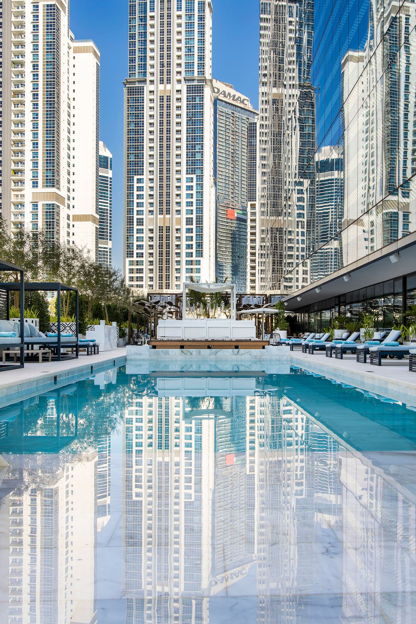 a pool with chairs and a building in the background