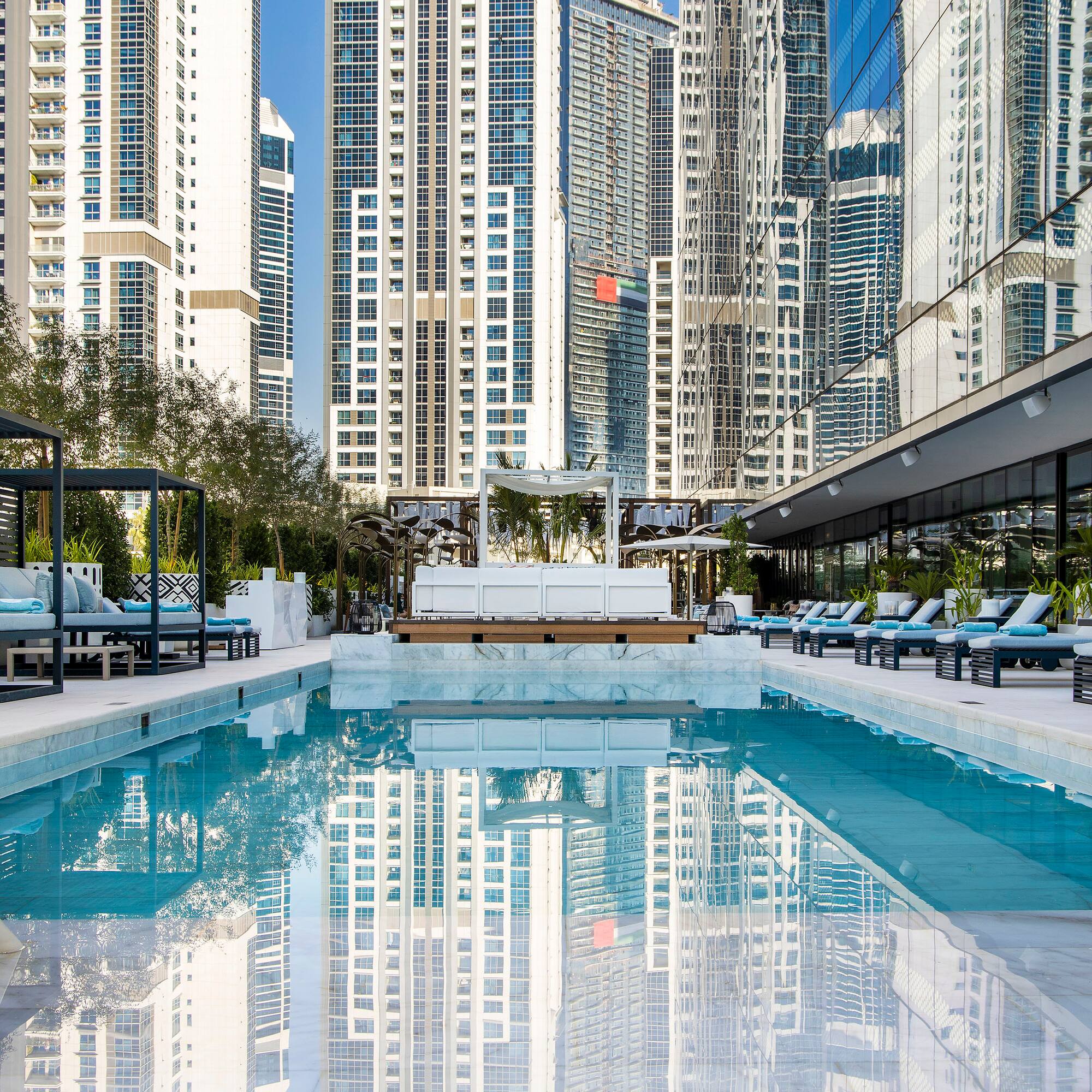 a pool with chairs and a building in the background
