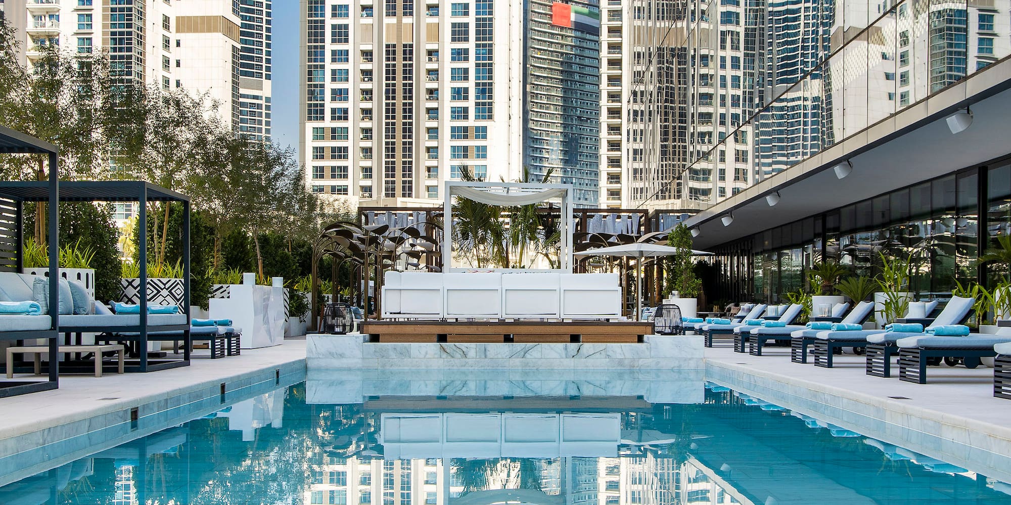 a pool with chairs and a building in the background