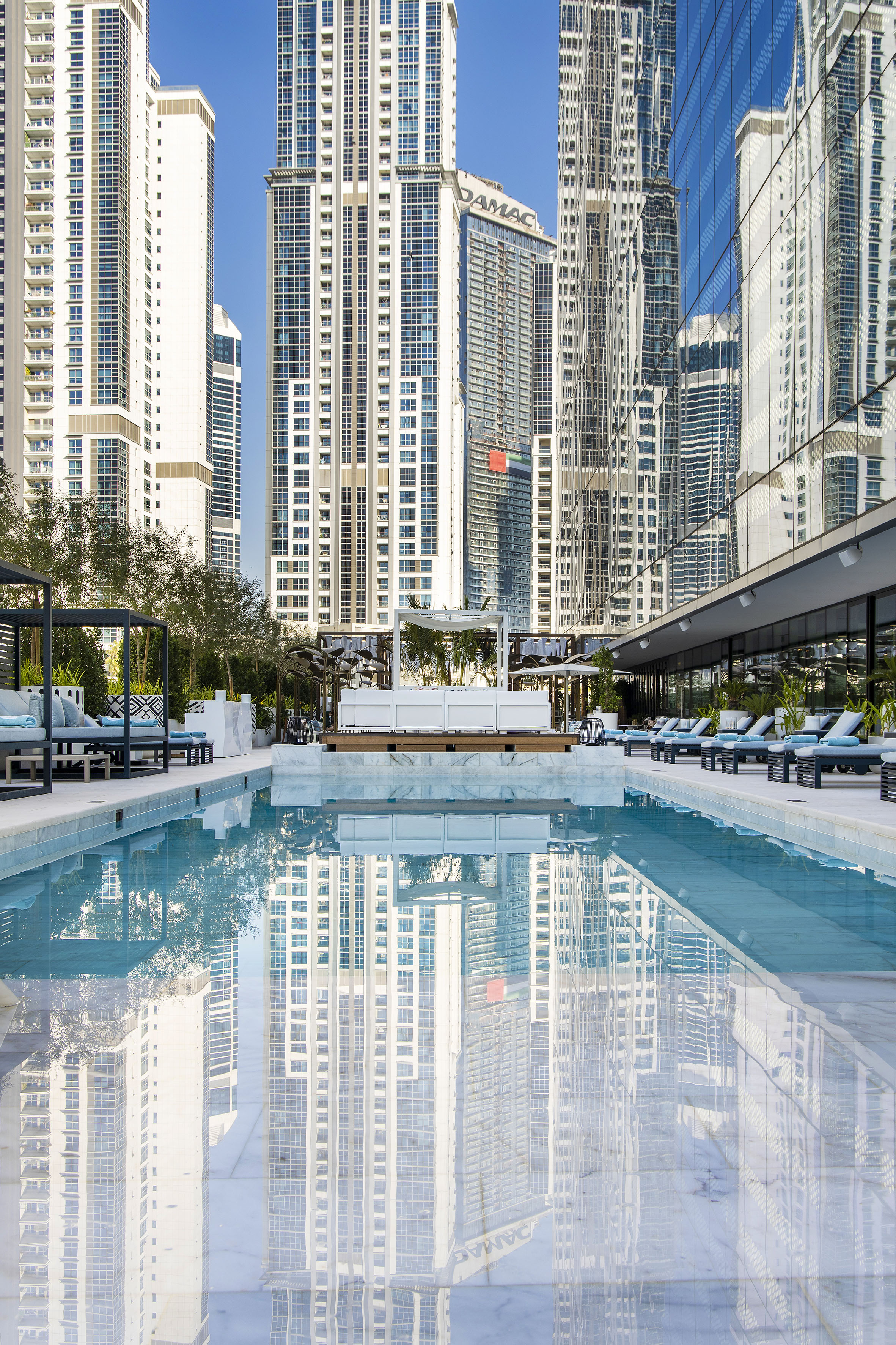 a pool with chairs and a building in the background