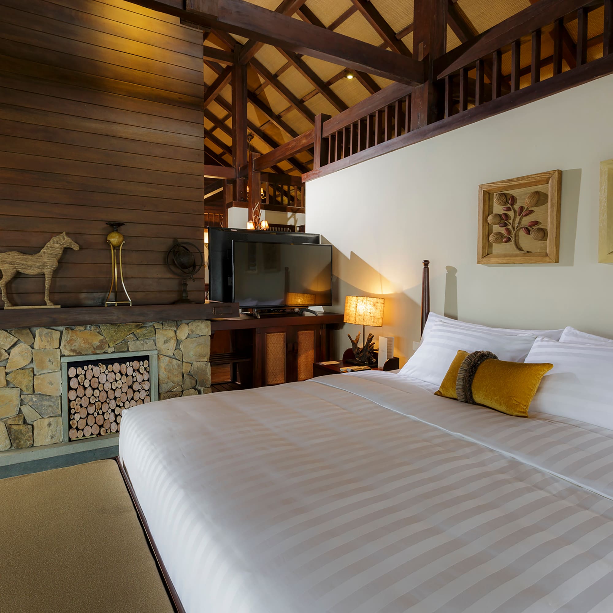 a bed in a room with a fireplace and a tv