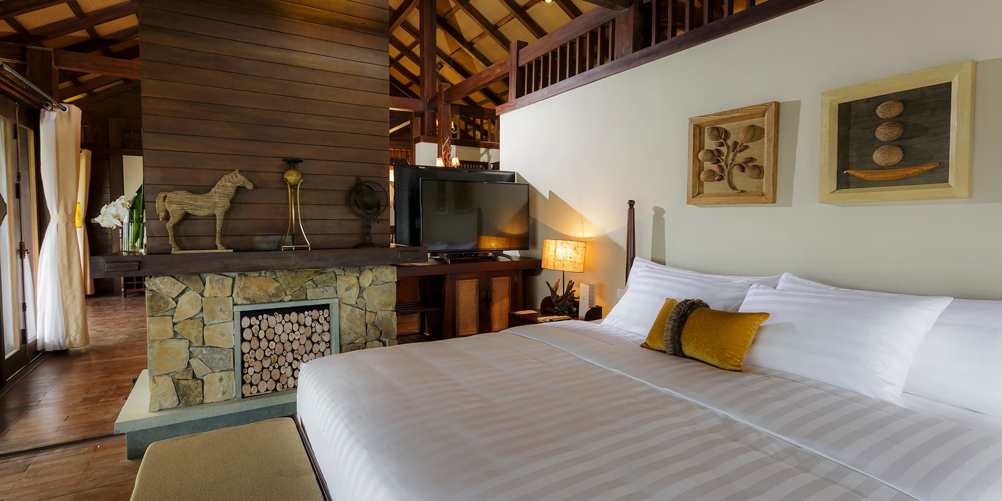 a bed in a room with a fireplace and a tv