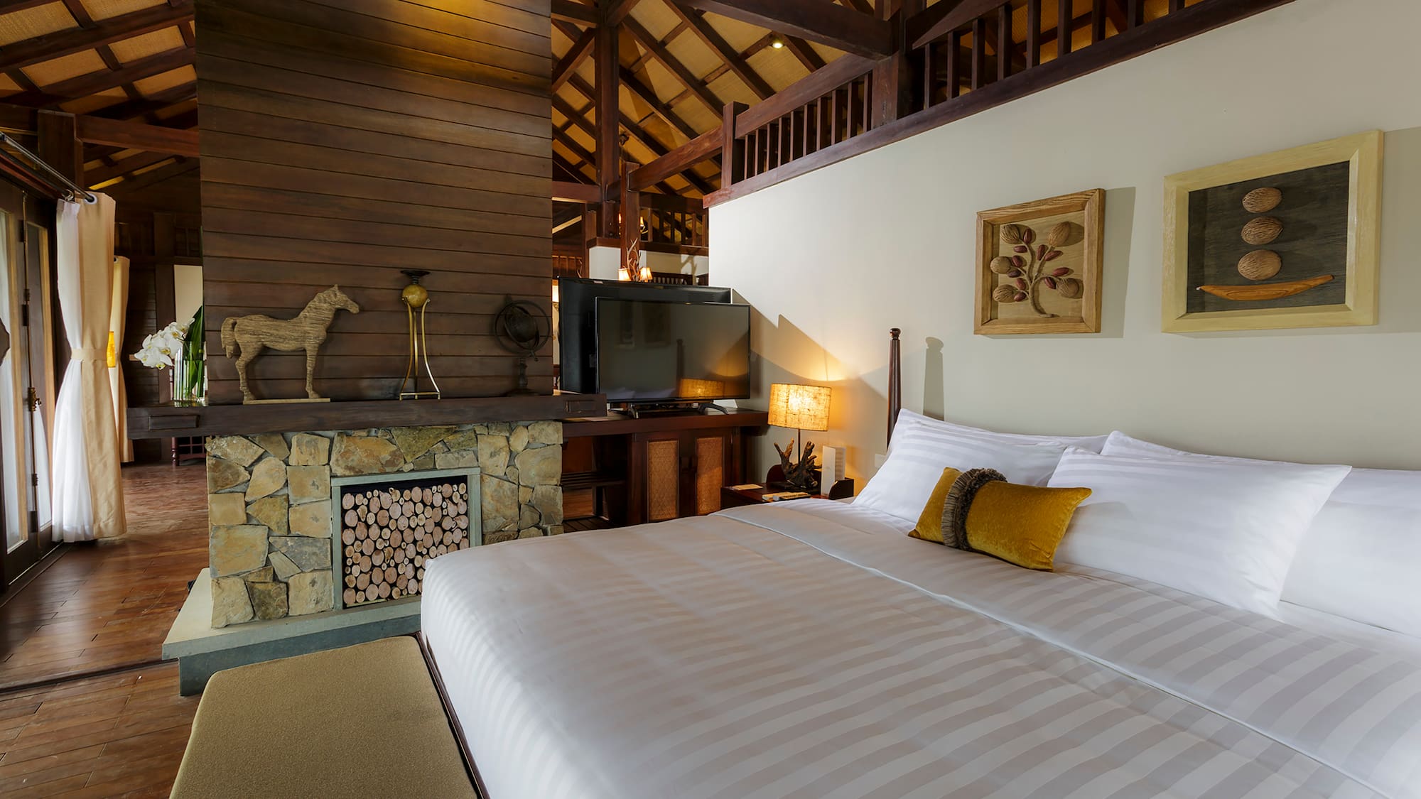 a bed in a room with a fireplace and a tv