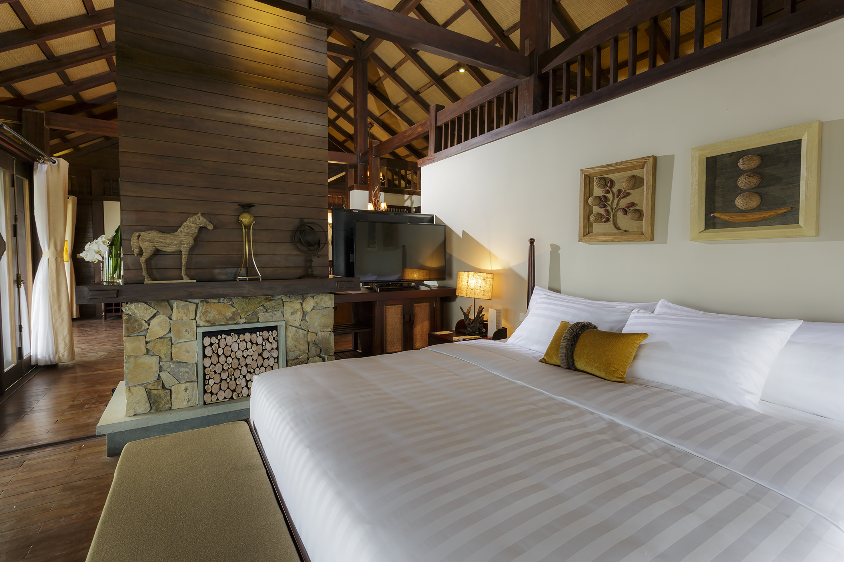 a bed in a room with a fireplace and a tv