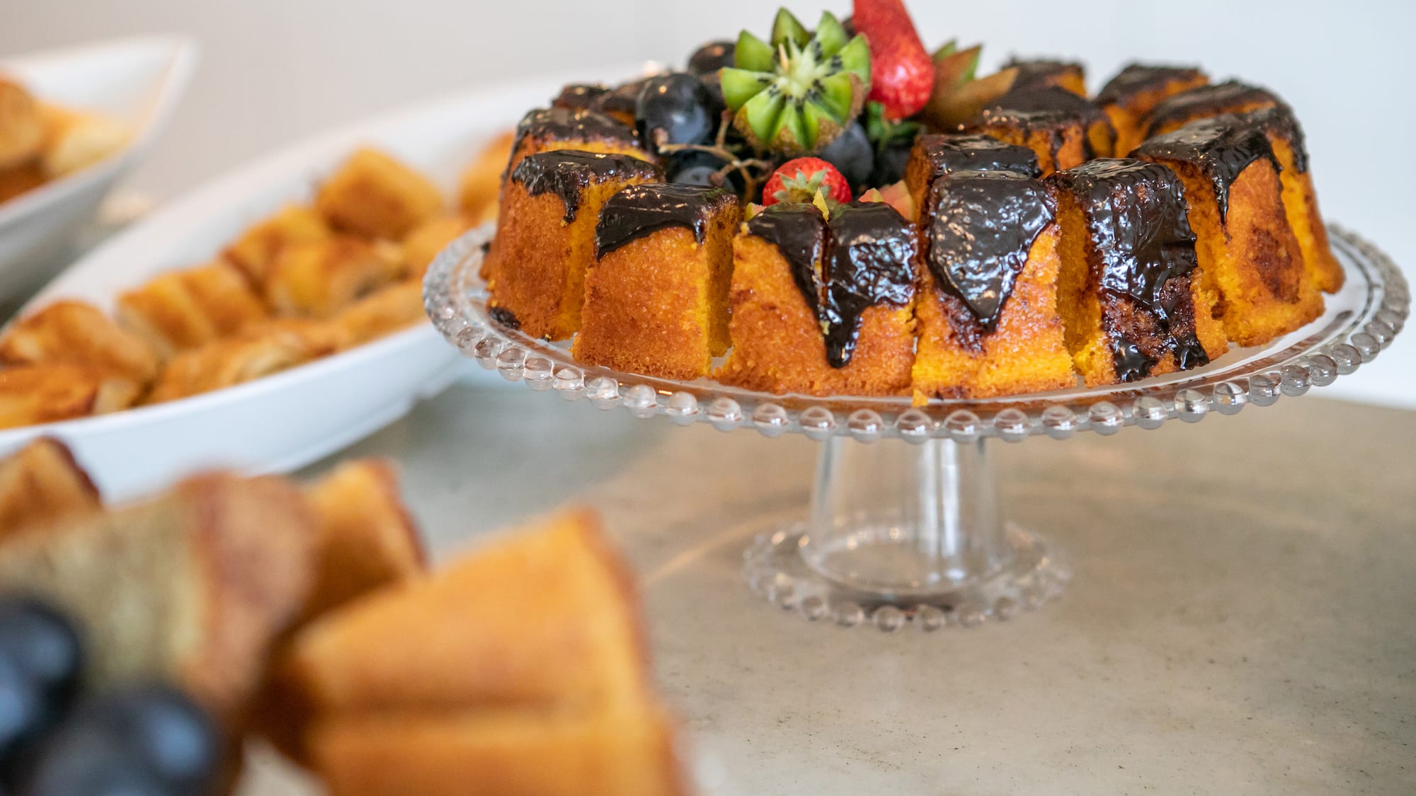 a cake with chocolate frosting and fruit on a plate
