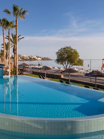 a pool with palm trees and a beach and a boat