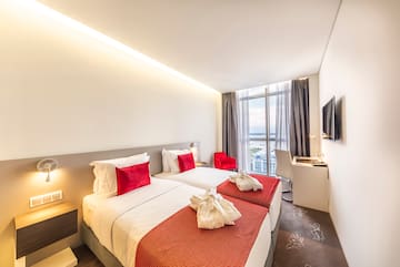 a hotel room with two beds and a tv