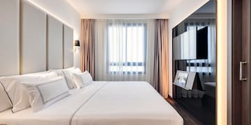 a bedroom with a large bed and a mirror