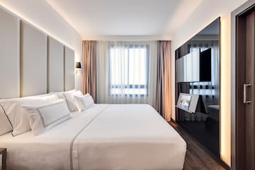 a bedroom with a large bed and a mirror