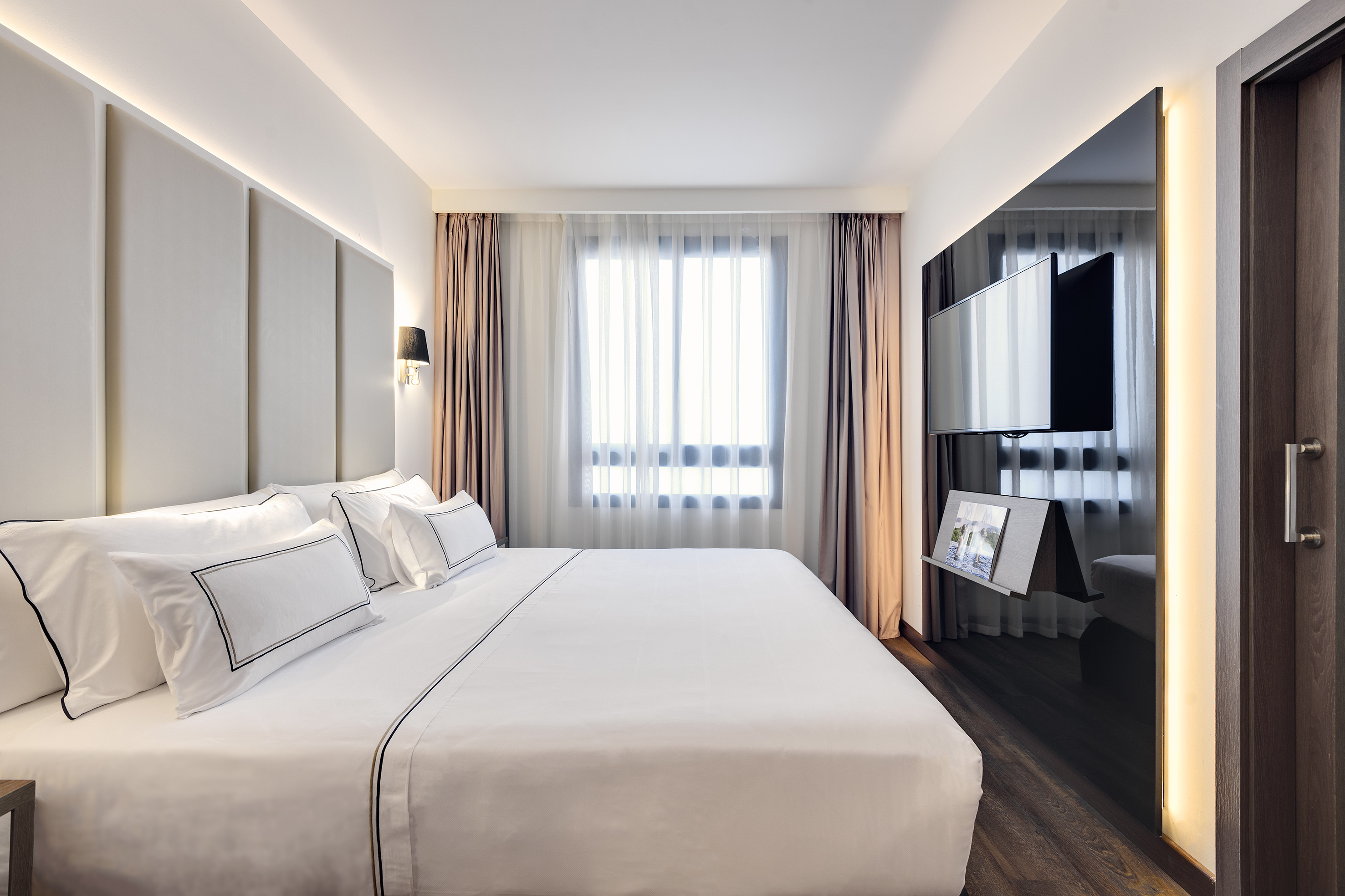 a bedroom with a large bed and a mirror