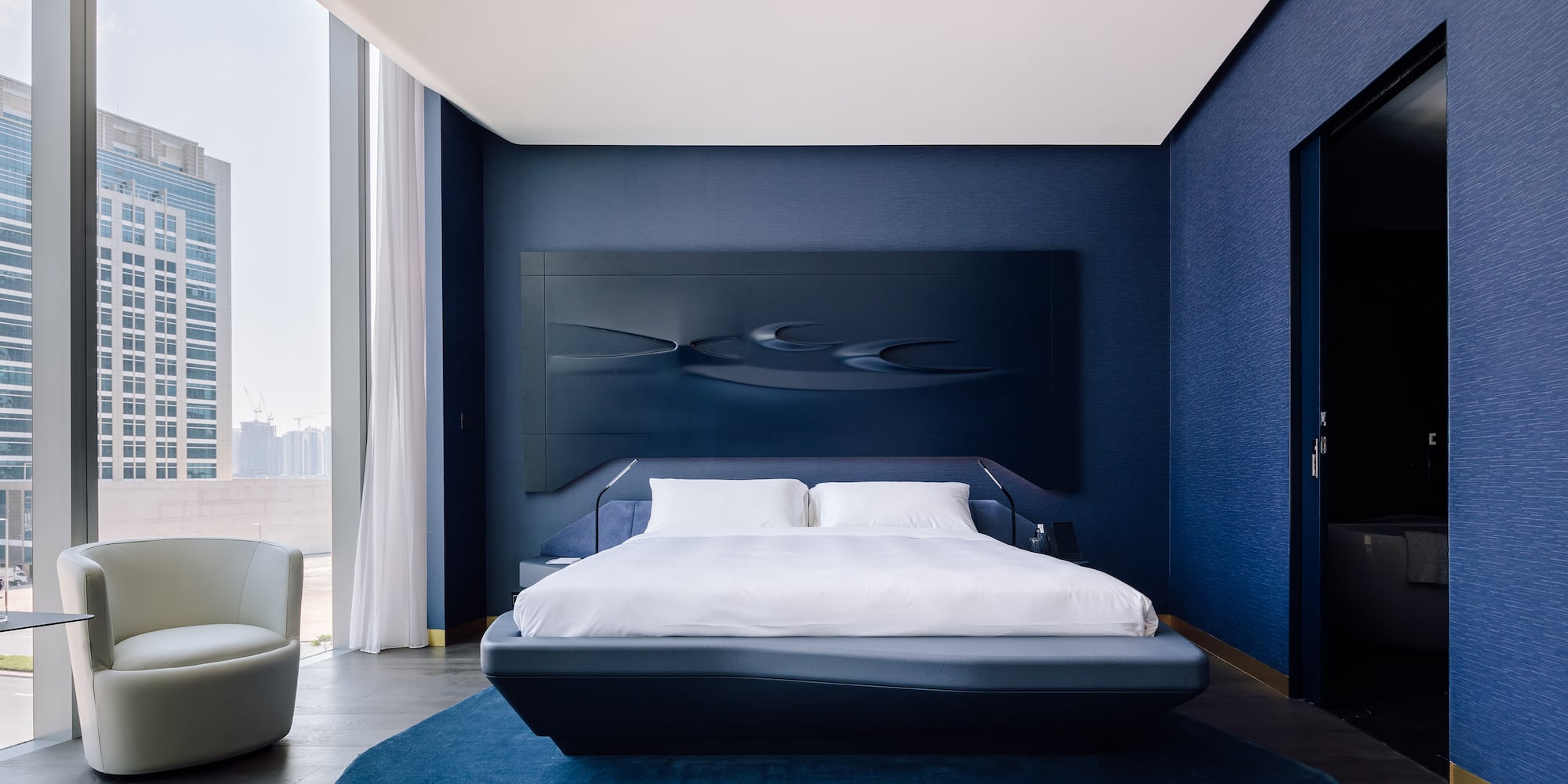a bedroom with a bed and a blue wall